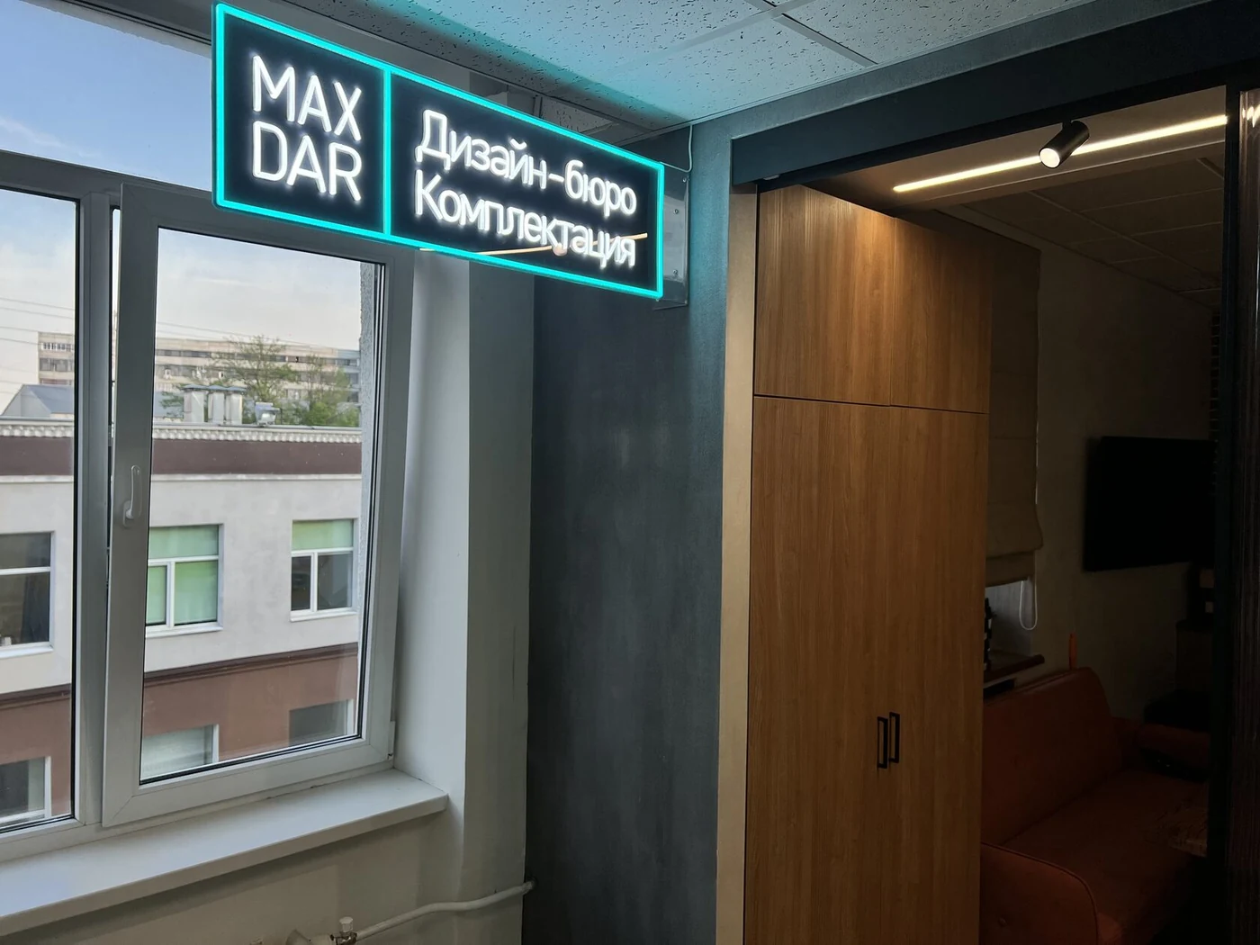 Бирюзовая световая композиция MAXDAR на тёмной стене рядом с окном