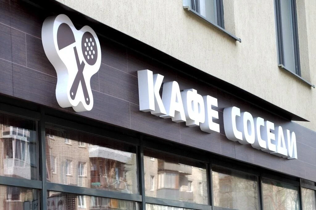 Объёмные белые буквы КАФЕ СОСЕДИ и знак чашки над входом