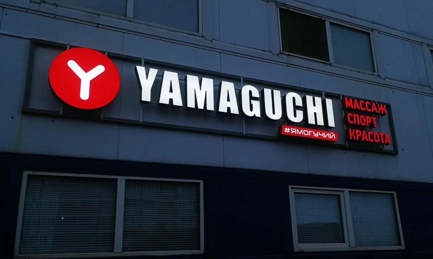 Белые буквы YAMAGUCHI и красный круглый знак над входом